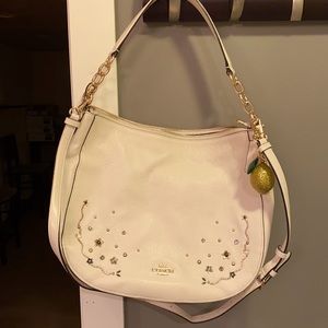 Beige coach purse with metal detailing